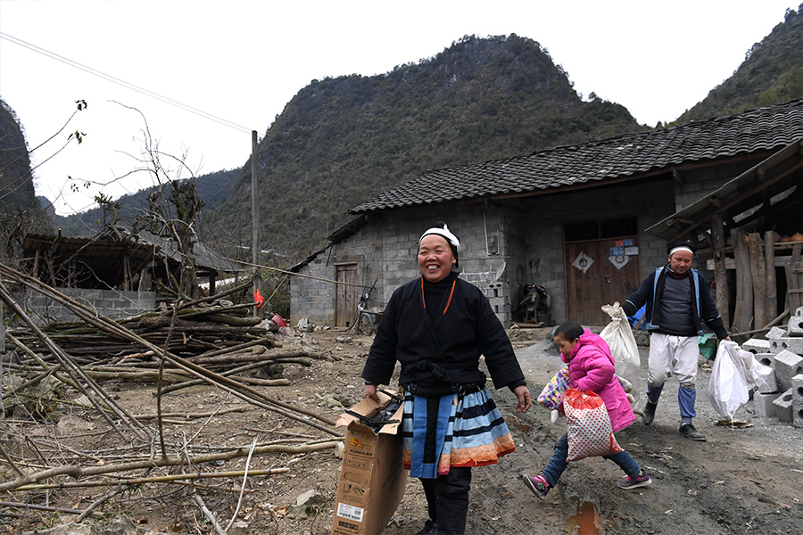 在南丹县八圩瑶族乡吧哈村,黎治明(右一)一家正准备搬往新家(2月4日摄