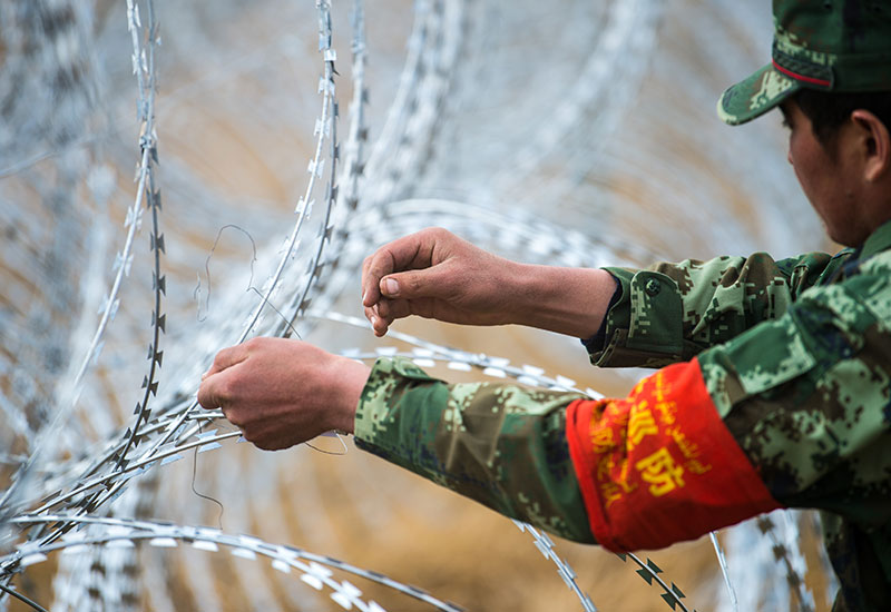 护边员阿不都克里木·米曼在边境线修整铁丝网(2017年5月7日摄).