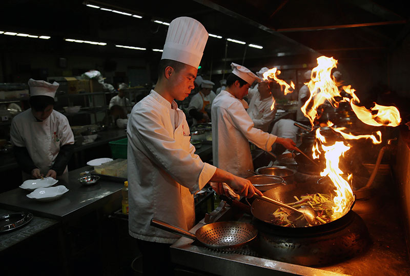 2015年除夕,文茂在长沙餐饮老字号玉楼东酒家厨房为客人烹制年夜饭(2